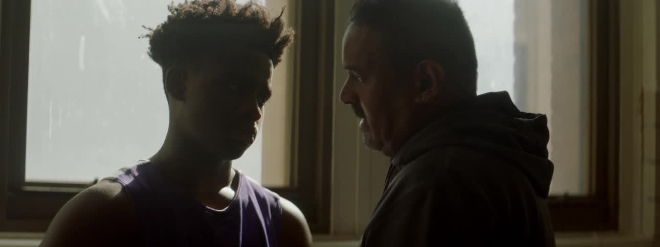 An older man talks to a young man