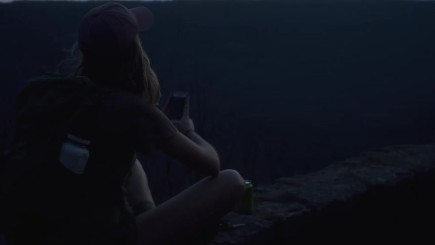 A young woman is taking pictures of the view around the nature area