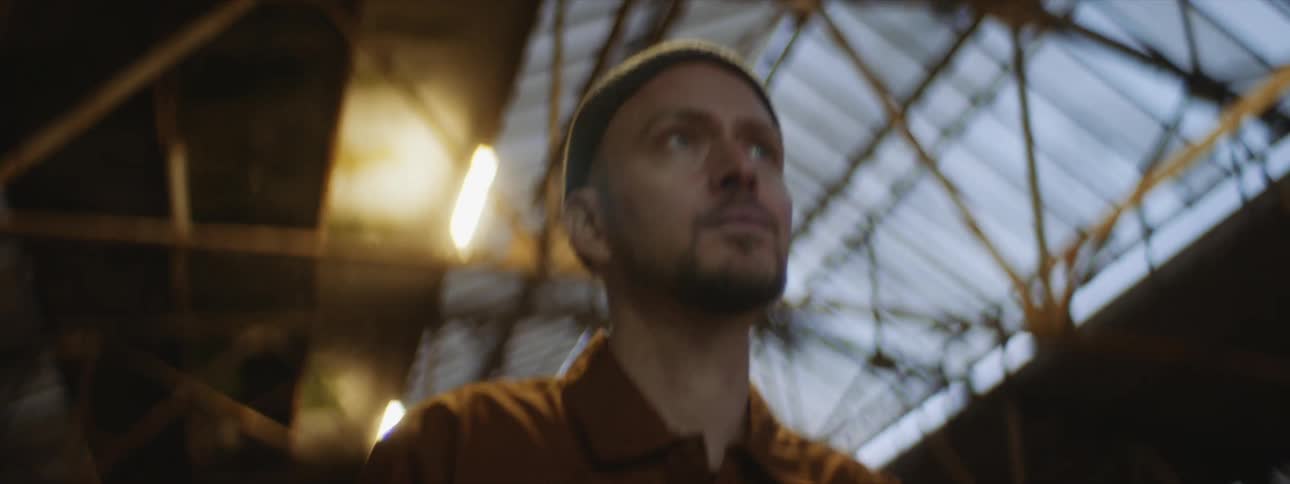 A man walks toward the camera in a large open building