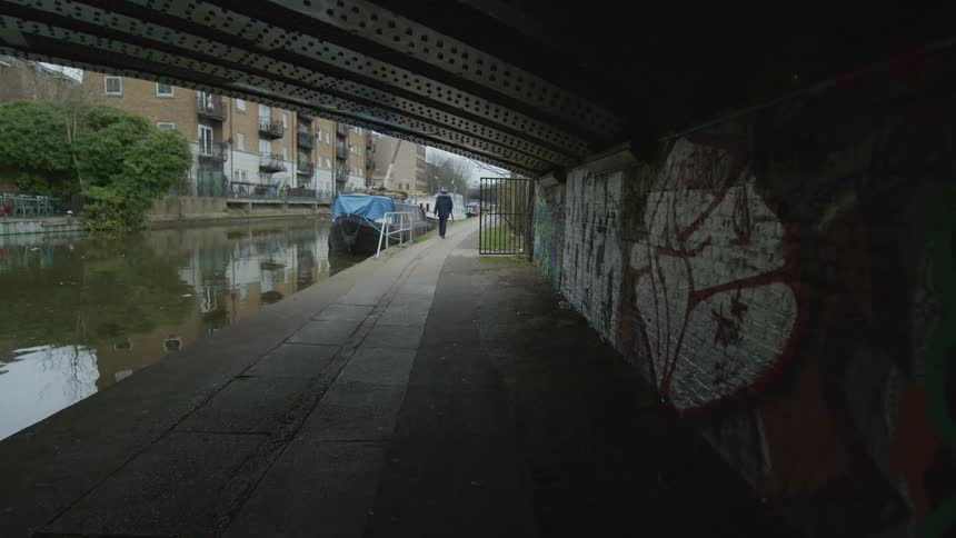 A man is walking by the canal