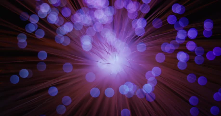 An up close of a laser light with colors on the end of spokes as it spins around