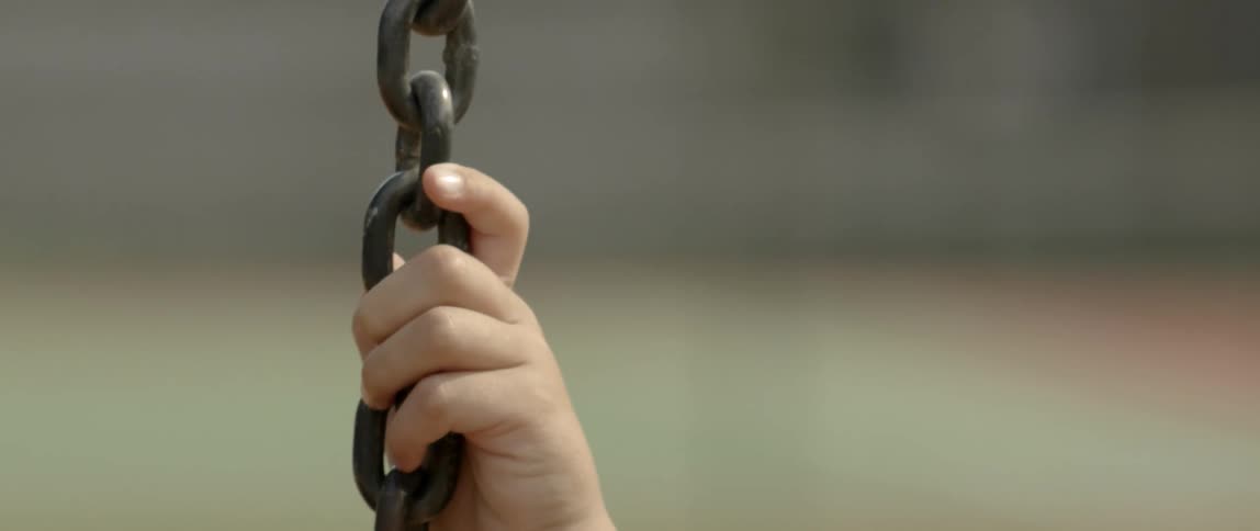 A child holds on to a chain