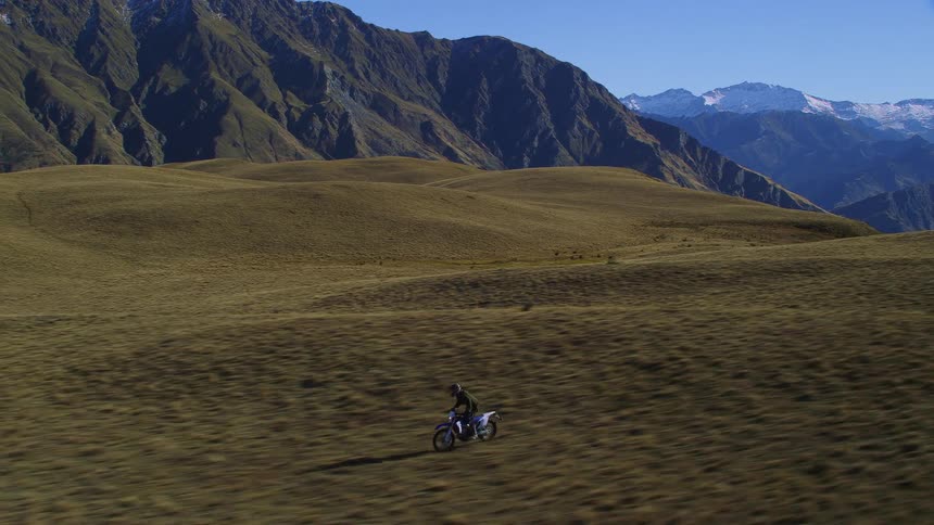 Person riding their motorcycle through a rocky terrain