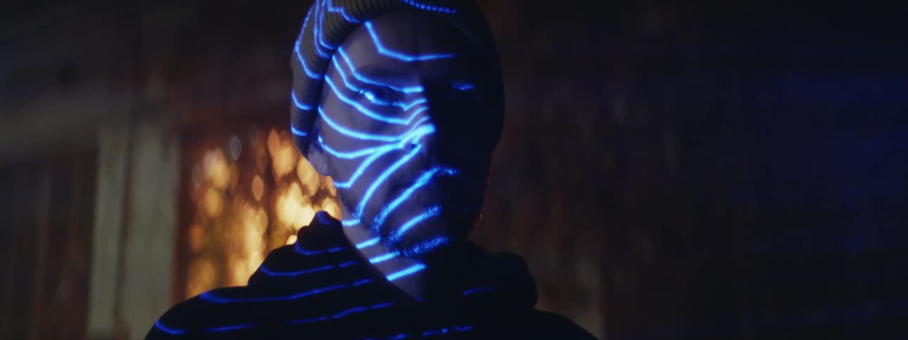 The view is of a man inside of his house at night time