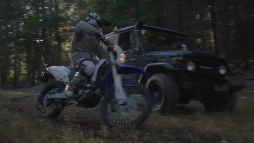 A girl rides a motorcycle into the forest