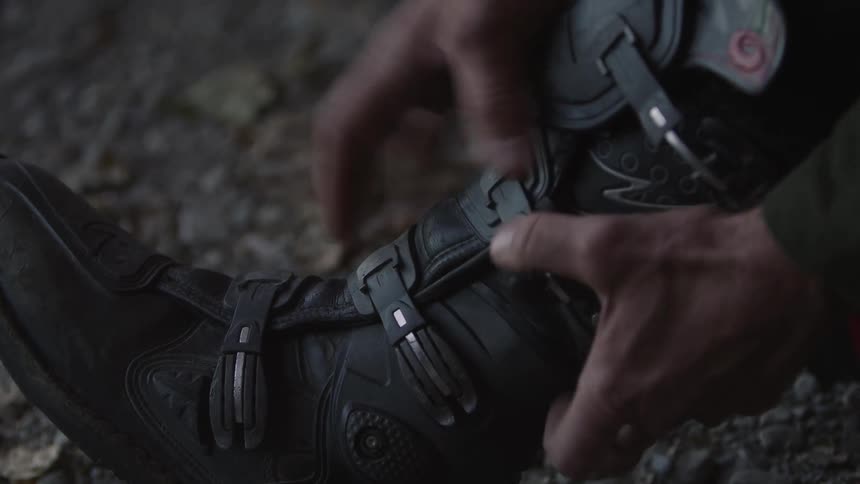 A person closes the latches on their boots