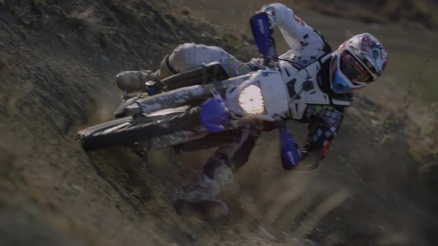 A man rides a motorcycle through a dirt pit