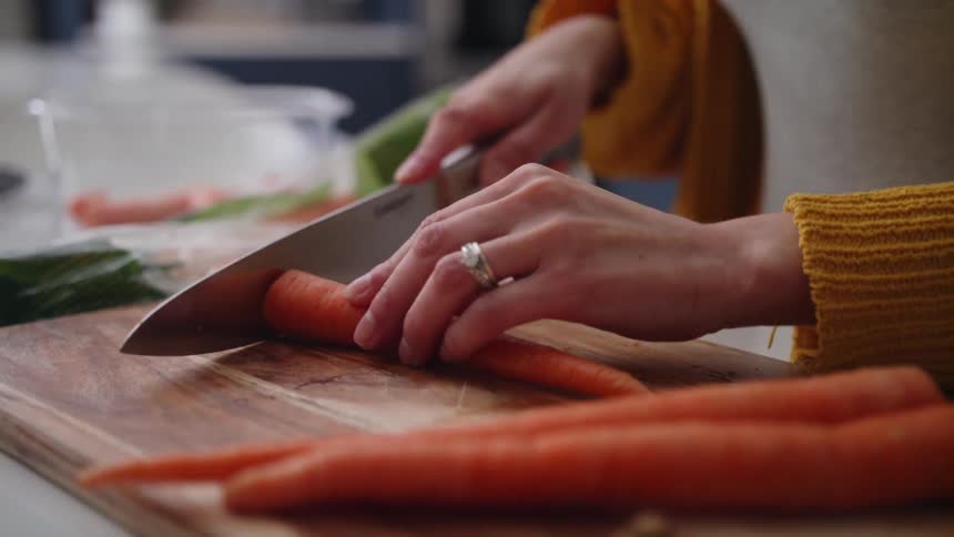 A woman cutting up carrots