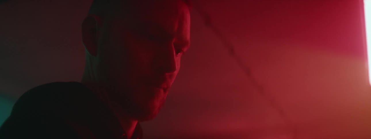 A man stands in a room with coloring changing overhead lights