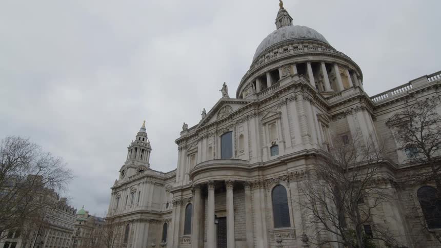 A drone view of an old monumental building with tall front pillars and a dome top