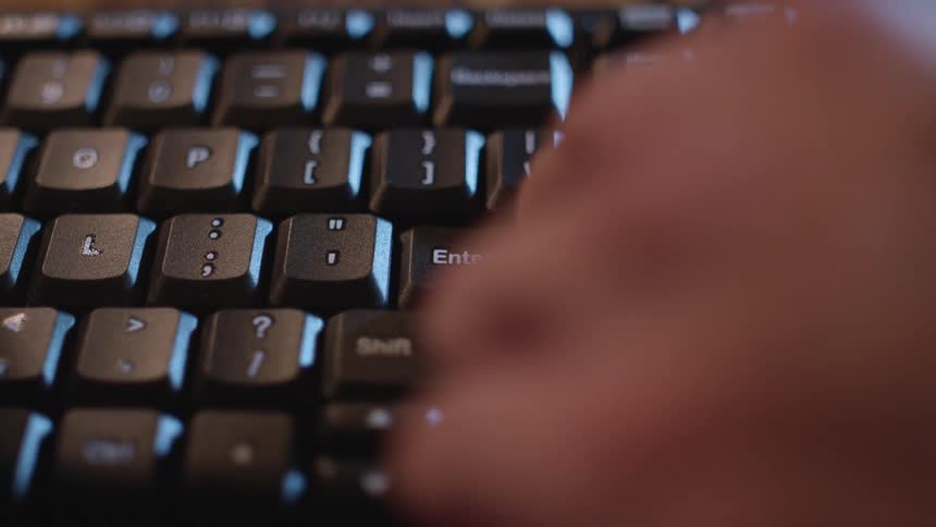 A person pressing the enter key