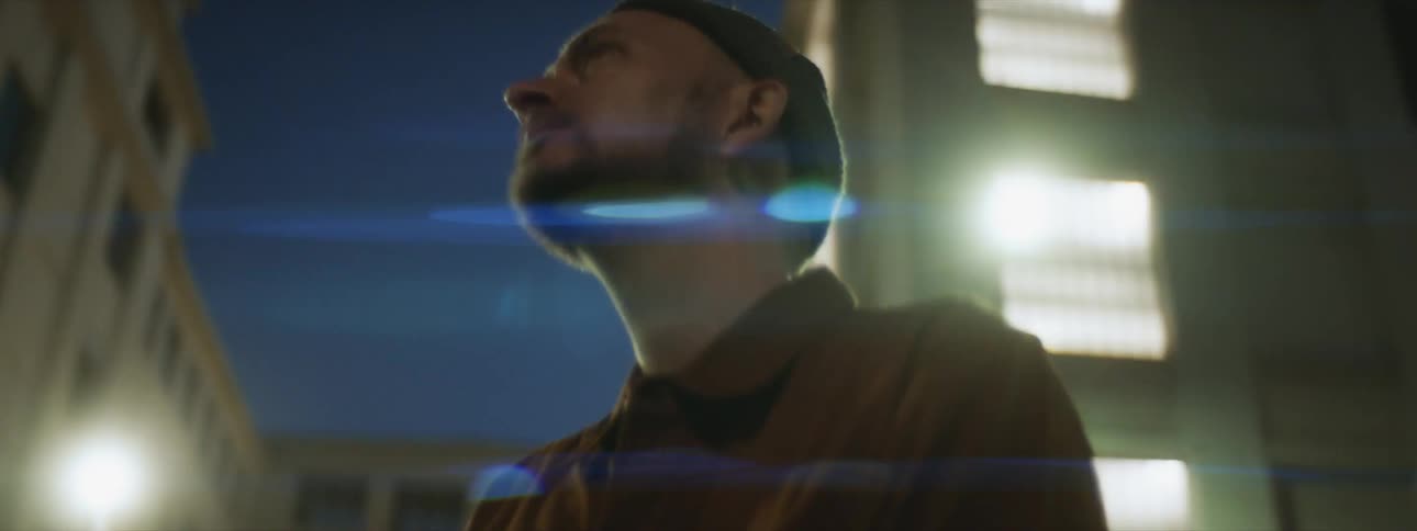 A man is sitting outdoors during the night time