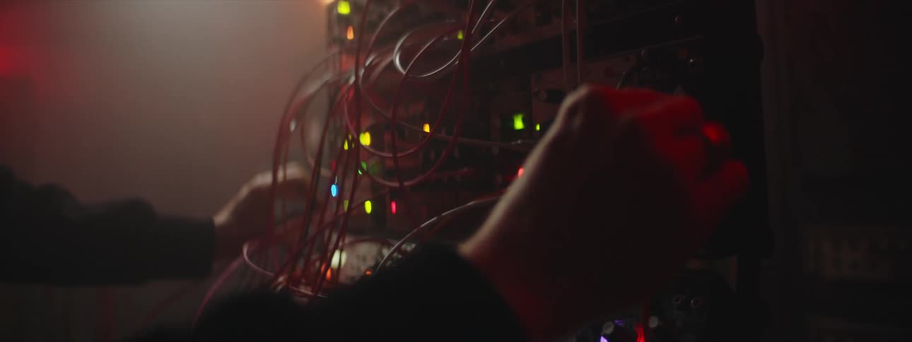 An up close of an electronic bord with connections and cords a person is sing