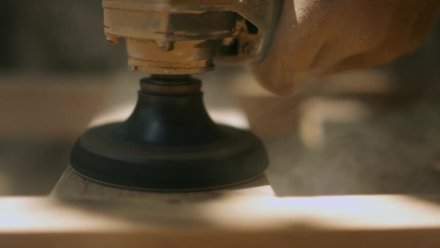 A person sanding something wooden
