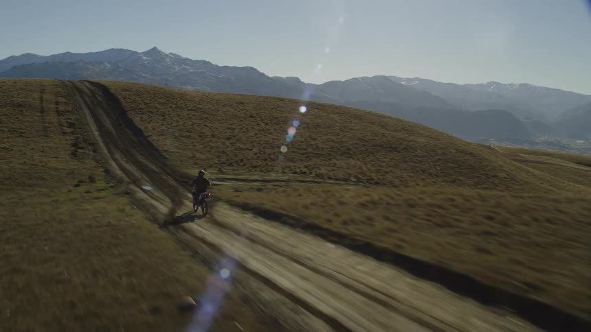A person is driving a motorcycle in a wilderness area