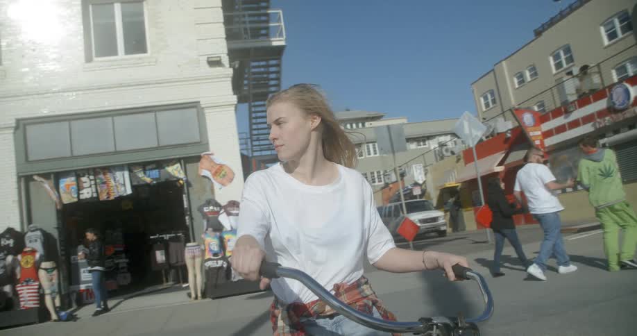 A woman sits on a bike in the street