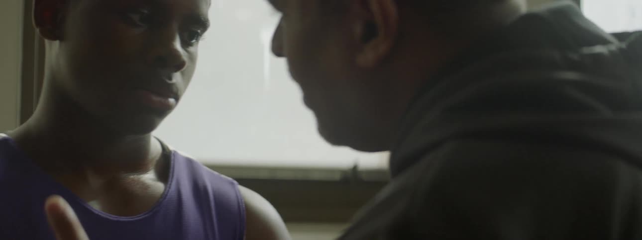 Two men talk to each other standing close