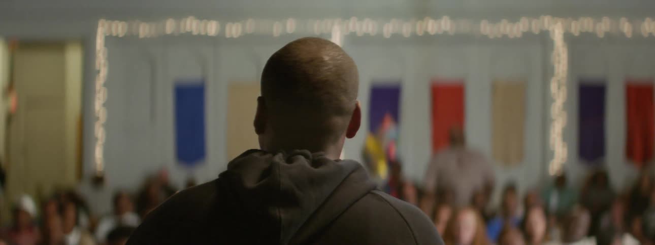 A man is talking to a crowd of people in front of him