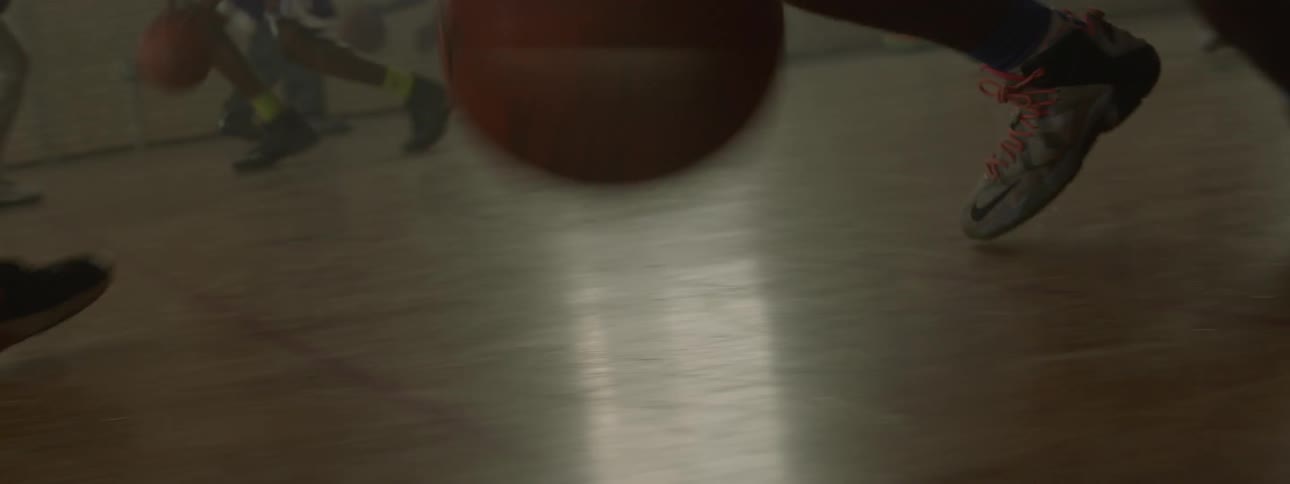 A basketball player is practicing with a coach