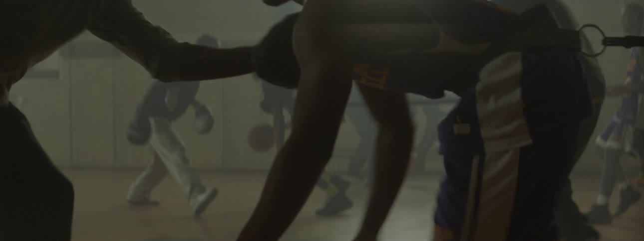 People are dribbling basketballs in a gym