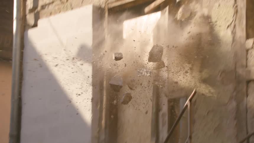 Rocks fall off the side of a building