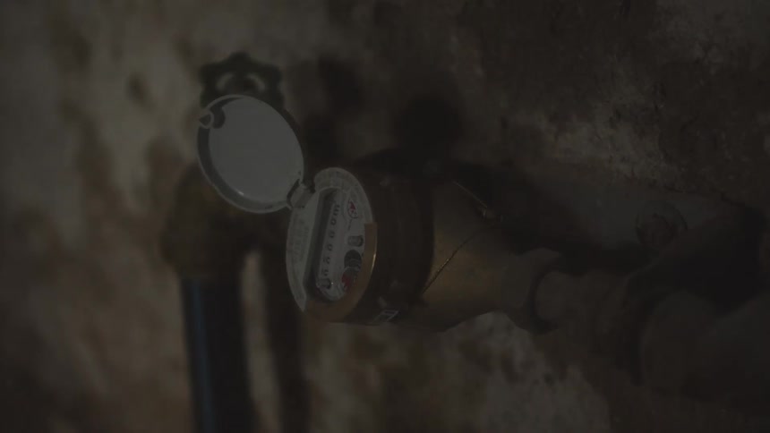 A valve pipe is connected to the side of a cement wall