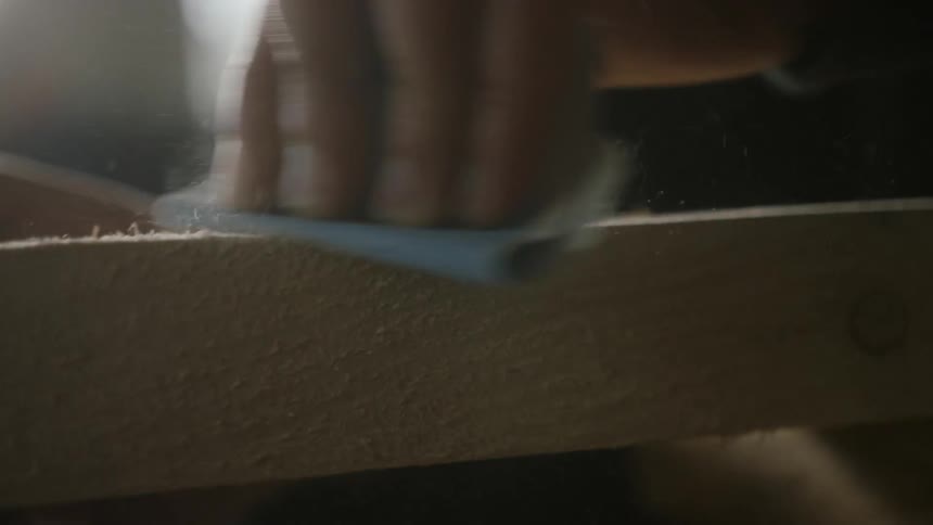 A carpenter sands wood