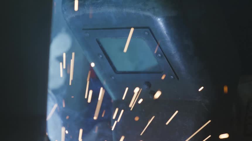 Sparks and smoke fly into the air near a machine