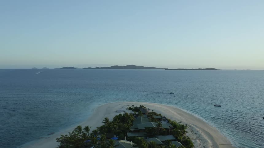 Aerial view of an island surrounded by ocean water is displayed