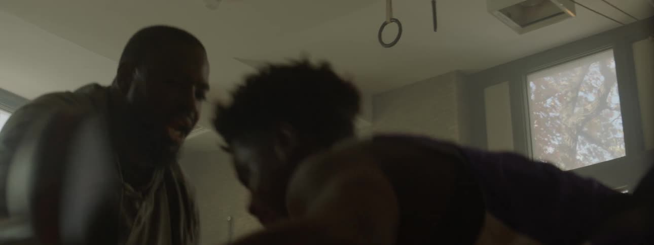 A wearing a harness train attacks a man who is pushing him back