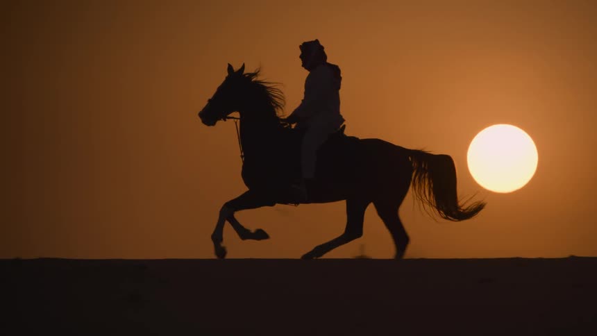 Silhouette of a person riding a horse at sunsets golden hour near a yellow bright sun
