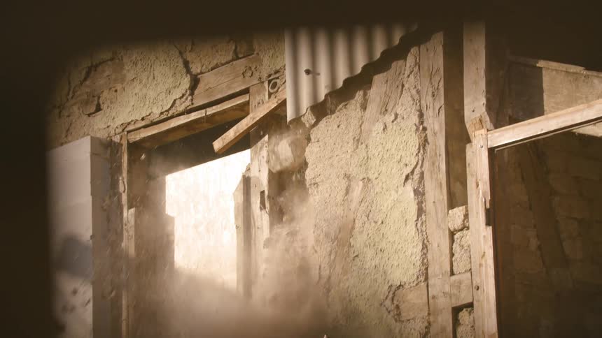 A rundown building being blasted and destroyed