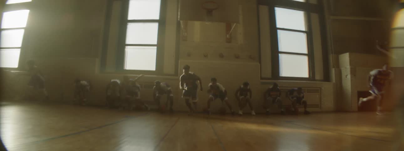 A team of basketball players sprint across the court