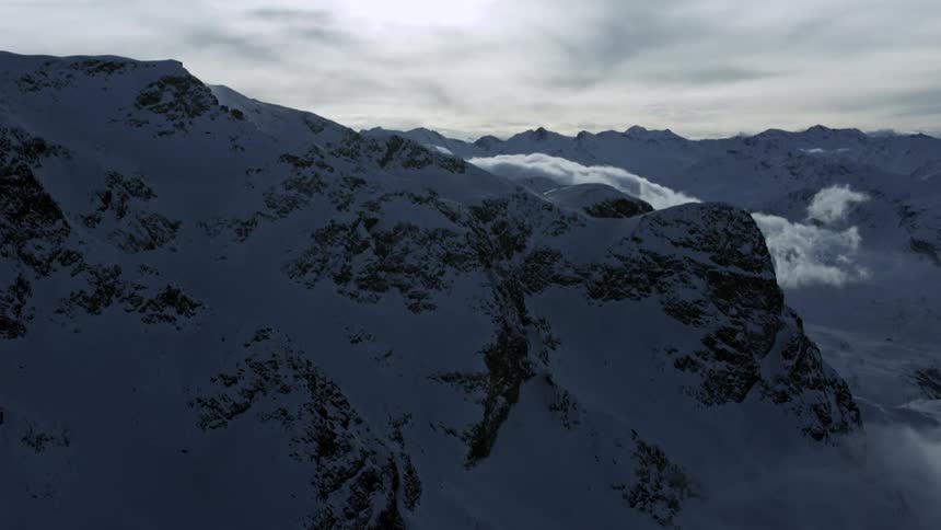 Aerial View: Clouds Shrouding Snowy St. Moritz Mountain Range in Daytime