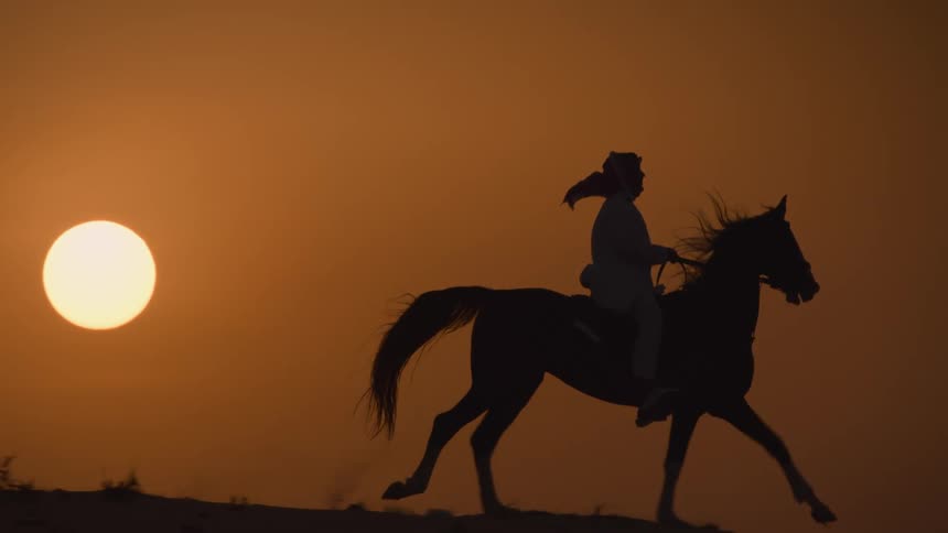 Someone is riding a horse outside in the desert