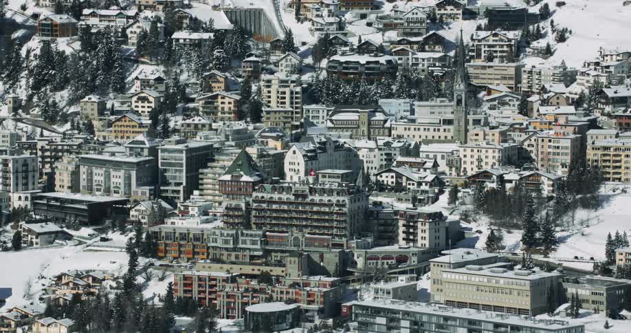 Aerial orbiting view of an european city on the slopes of a mountain at daytime