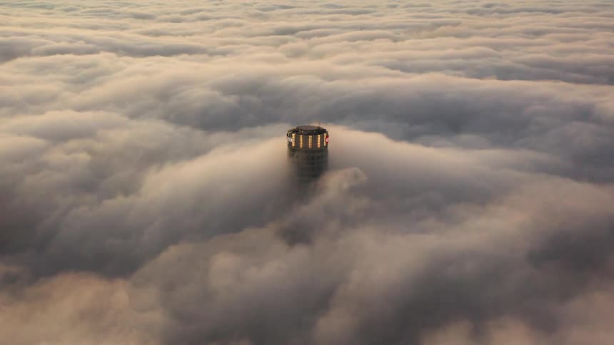 Dense clouds move over the top of a lighthouse