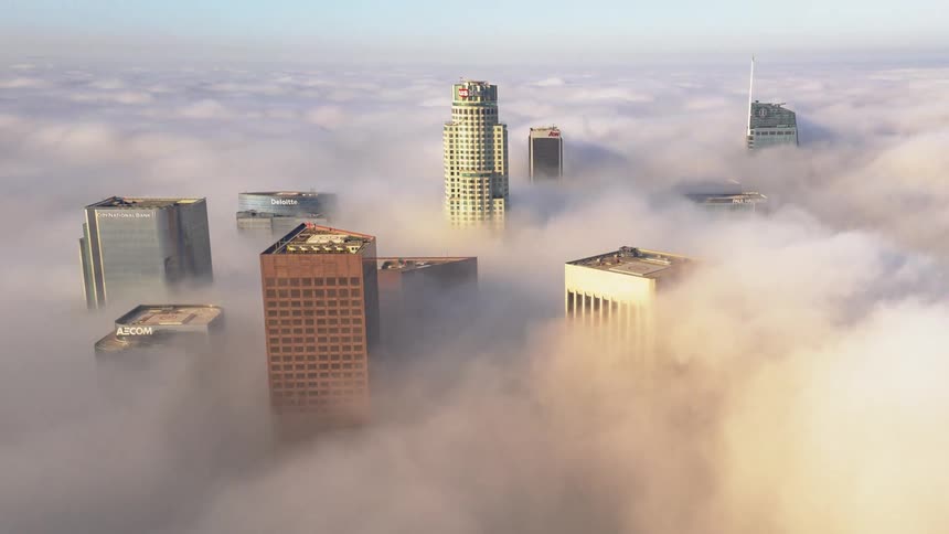 Aerial view of skyscrapers covered in fog in the city
