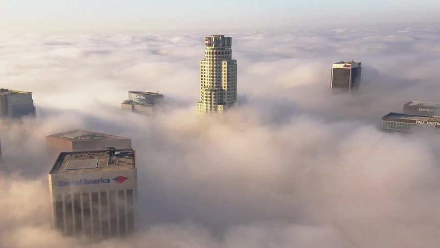 Aerial view of skyscrapers covered in fog in the city