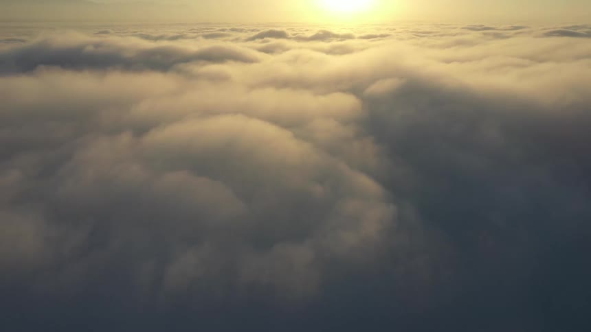 Aerial view of sun shining over clouds in the sky