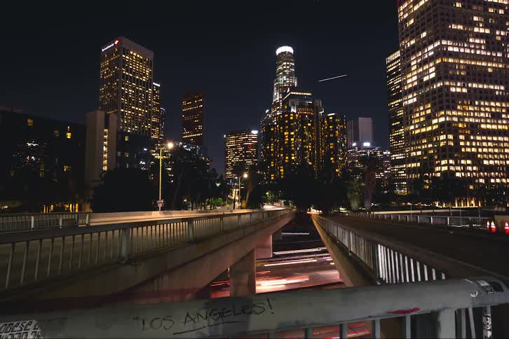 Heavy traffic passes under pedestrian bridges near downtown