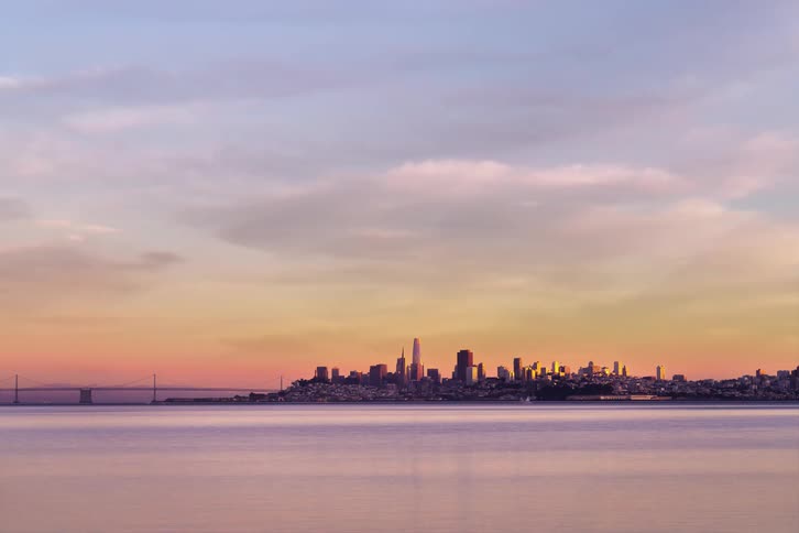 Time lapse of coastal city skyline with bridge