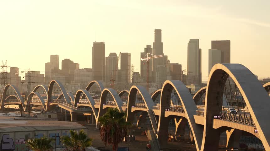Vehicles drive along a bridge leading in and out of downtown