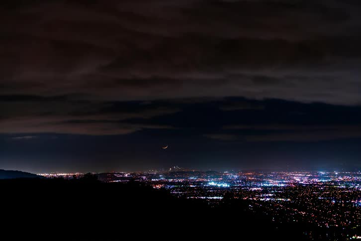 A time lapse shows clouds passing overhead above a city at night