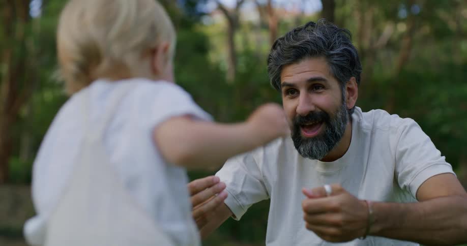 Father and daughter are playing outside in the nature area