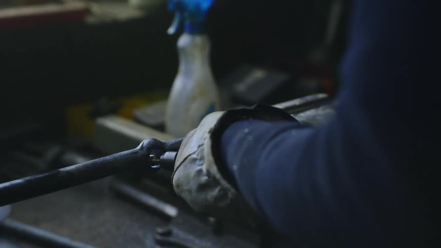 A man welds metal in his workshop
