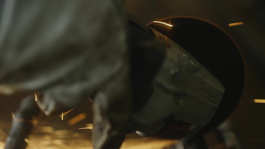 A person uses a power tool which generates tons of sparks as it cuts through metal