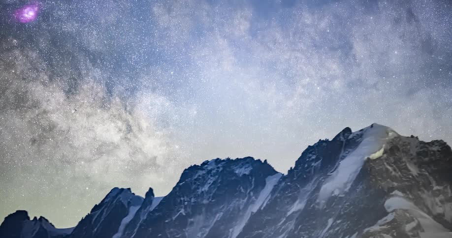 A starry night sky above a snow mountain range in nature