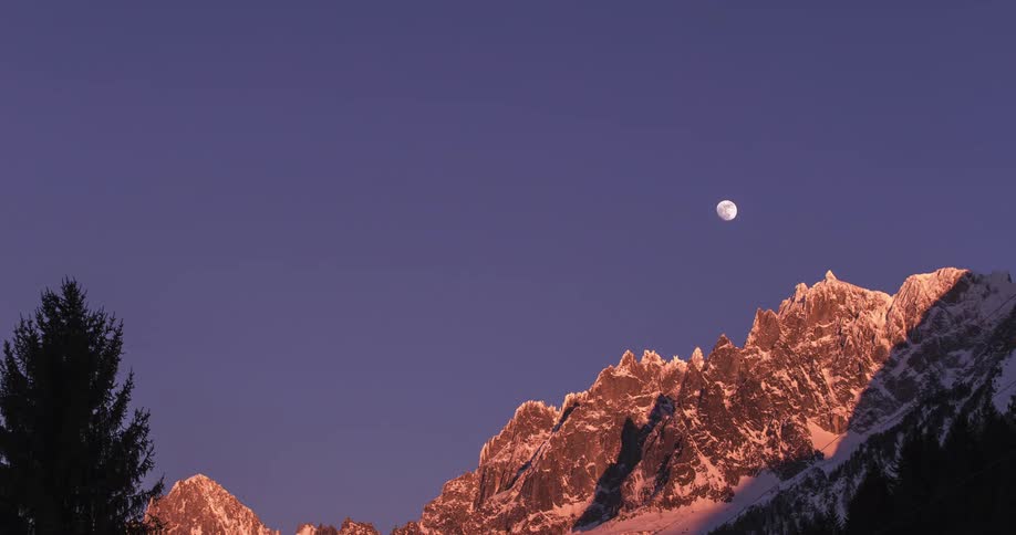 The moon is rising over the mountain