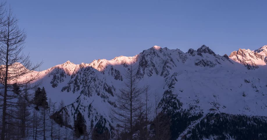 Time lapse of snowy mountain range during sunrise